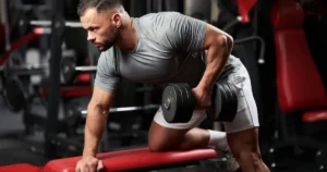 Man performing a dumbbell bent-over row during a pull day workout targeting back and biceps.