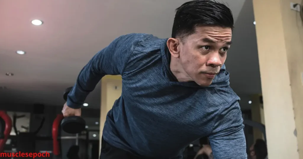 Beginner performing tricep kickbacks with dumbbells in a standing bent-over position to build arm strength and tone triceps.